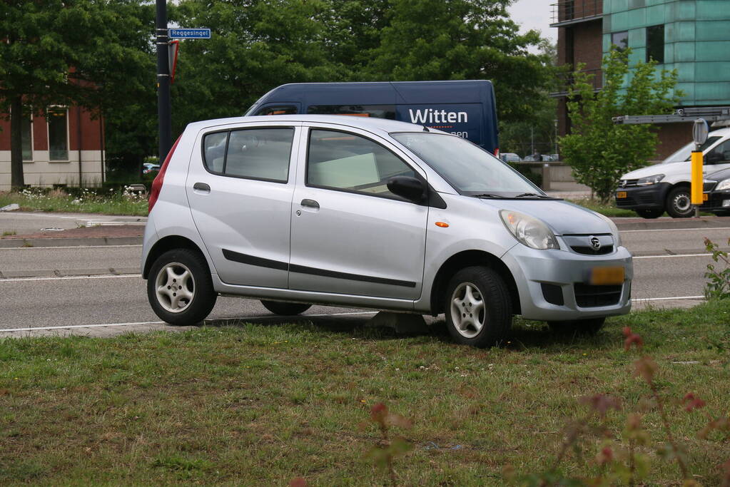 Auto zit vast op betonblok na verlaten van rotonde