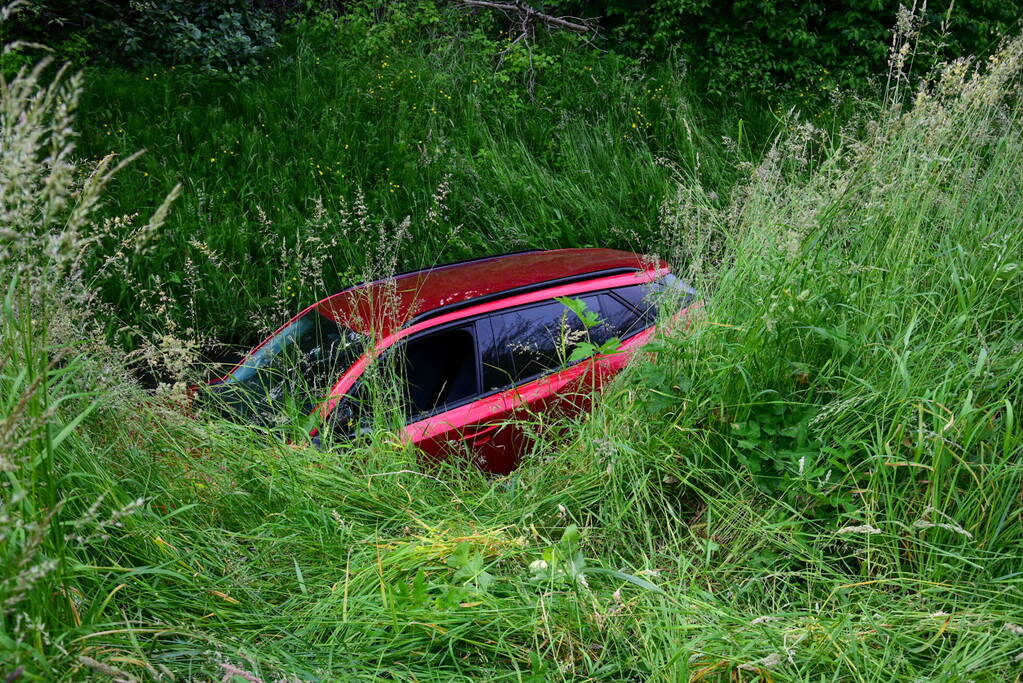 Auto rijdt over rotonde de sloot in
