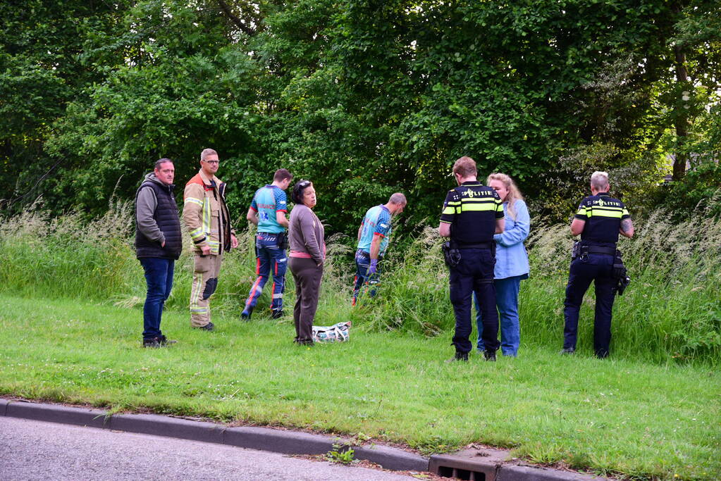 Auto rijdt over rotonde de sloot in