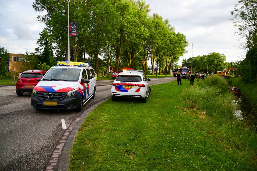 Auto rijdt over rotonde de sloot in