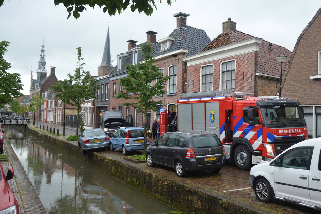 Auto bengelt op rand van gracht