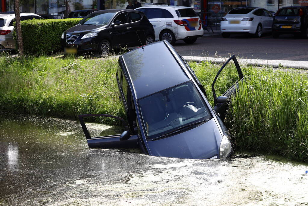 Geparkeerde auto belandt half in het water
