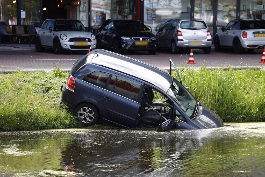 Geparkeerde auto belandt half in het water