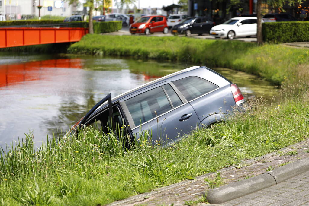 Geparkeerde auto belandt half in het water