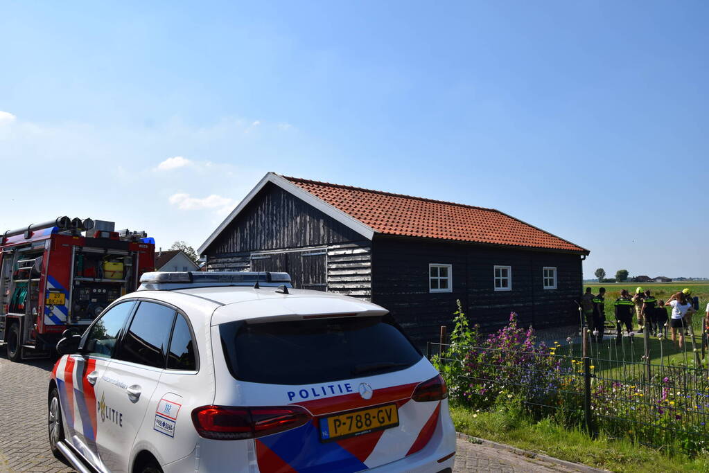 Houten balken achter schuur vlam gevat