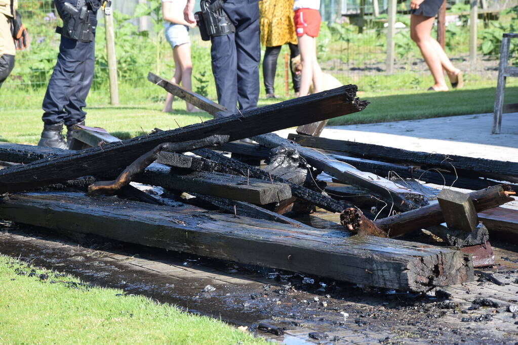 Houten balken achter schuur vlam gevat