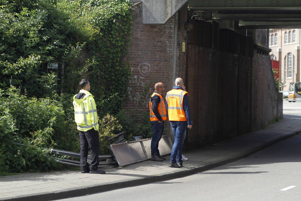 Vrachtwagen rijdt bord af van spoorbrug