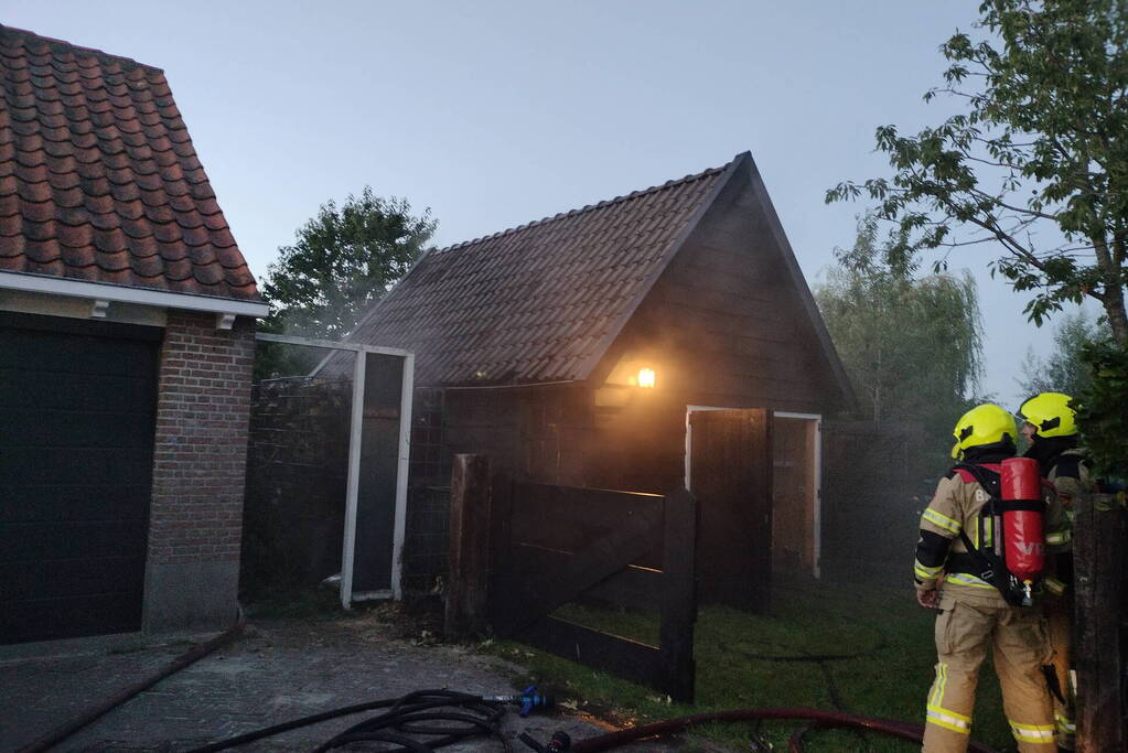 Haardhout tegen schuur in brand