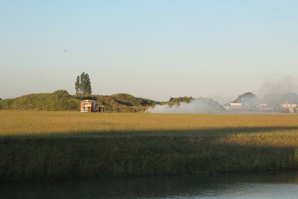 Auto midden in het veld verwoest vanwege brand