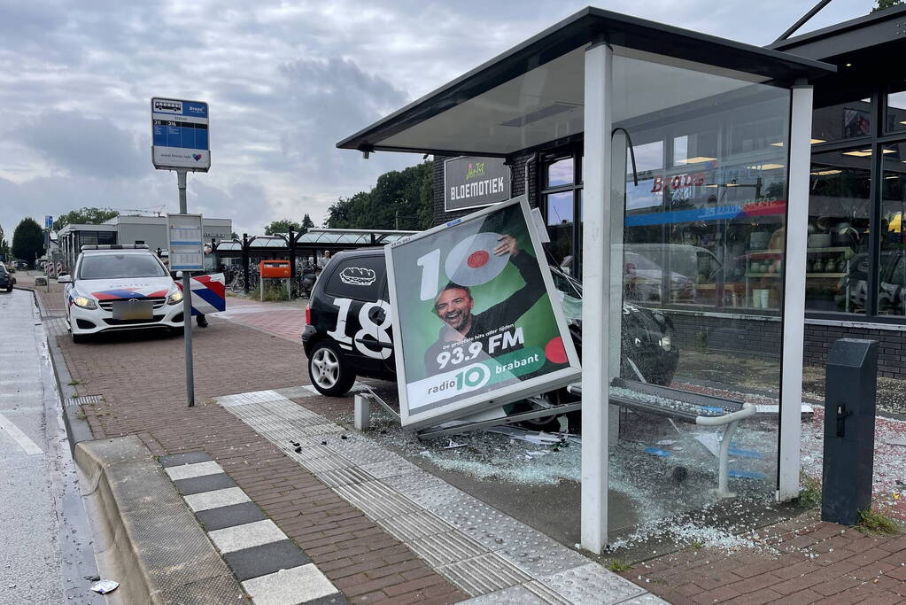 Auto crasht dwars door bushokje heen
