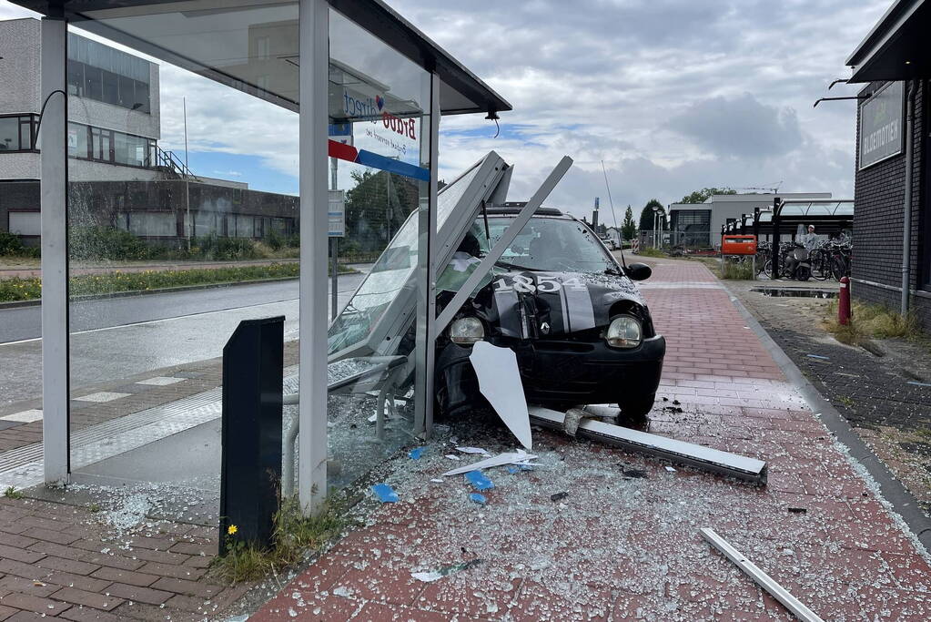 Auto crasht dwars door bushokje heen
