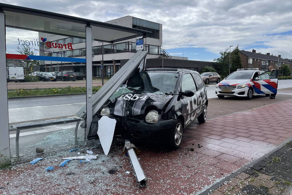 Auto crasht dwars door bushokje heen