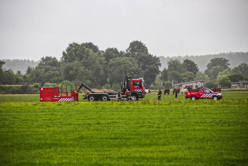 Paard met kraan uit sloot getakeld