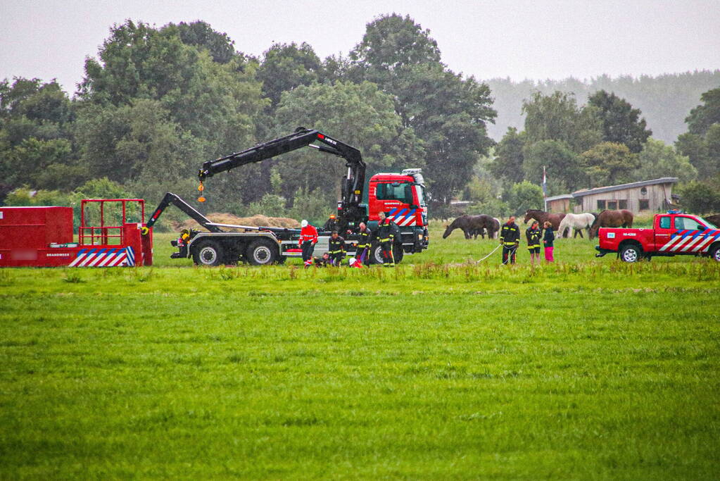 Paard met kraan uit sloot getakeld