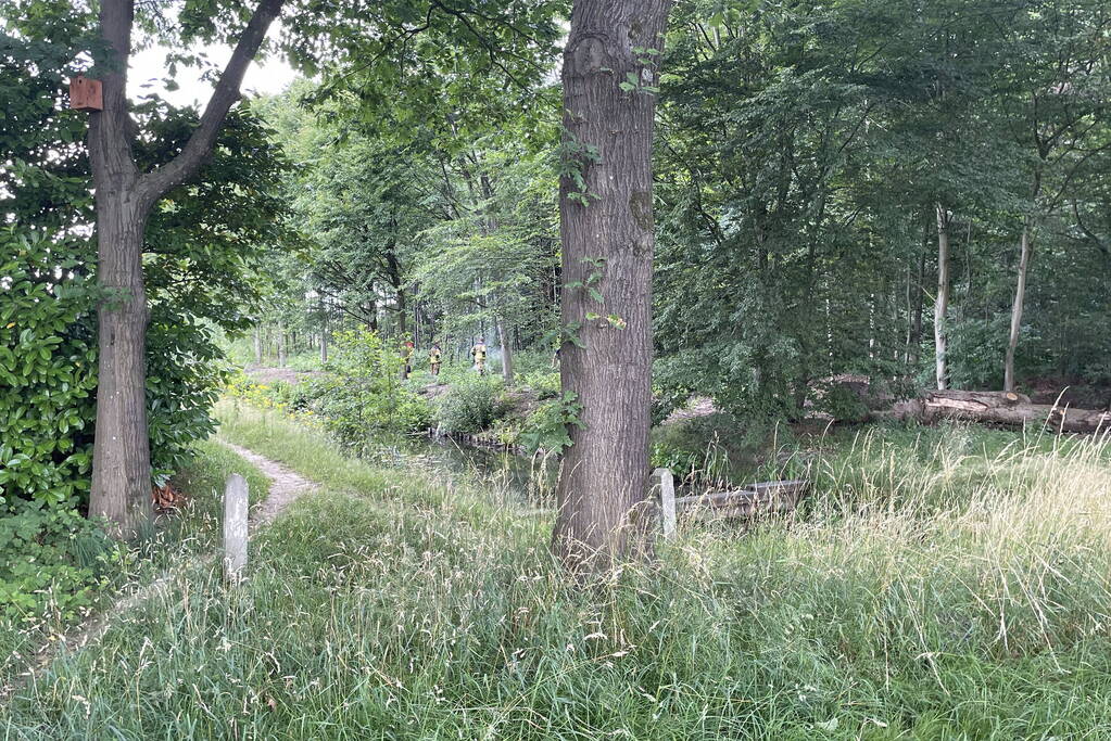 Brandweerlieden blussen brand in buitengebied