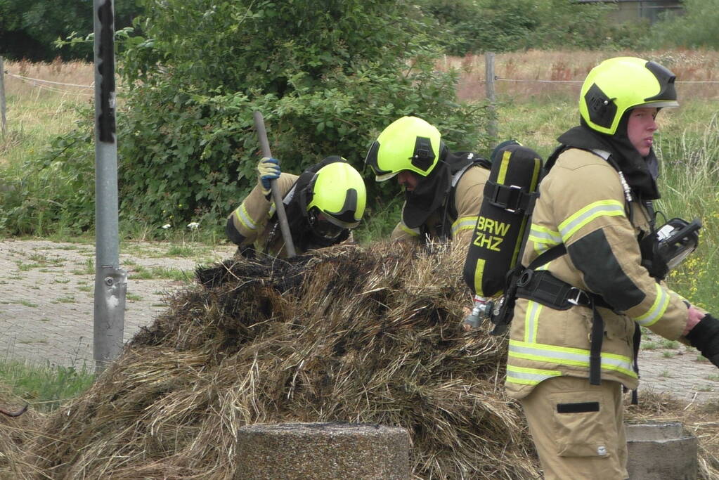 Brandweer blust brandende hooibaal