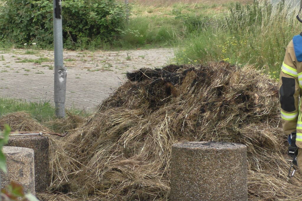 Brandweer blust brandende hooibaal
