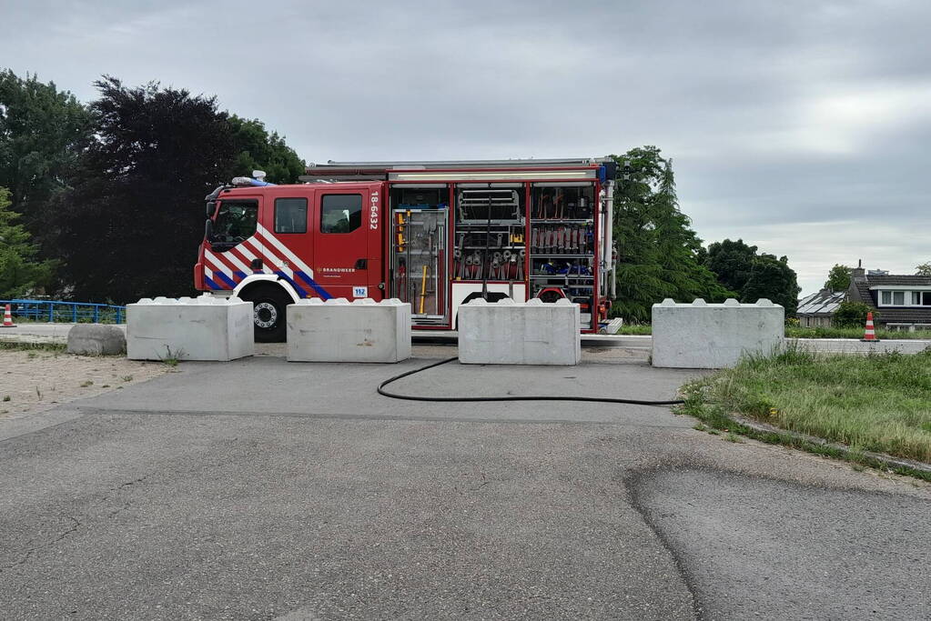 Brandweer blust brandende hooibaal