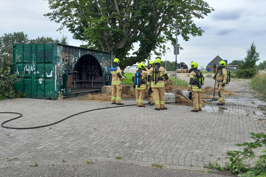 Brandweer blust brandende hooibaal