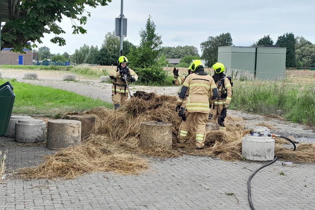 Brandweer blust brandende hooibaal