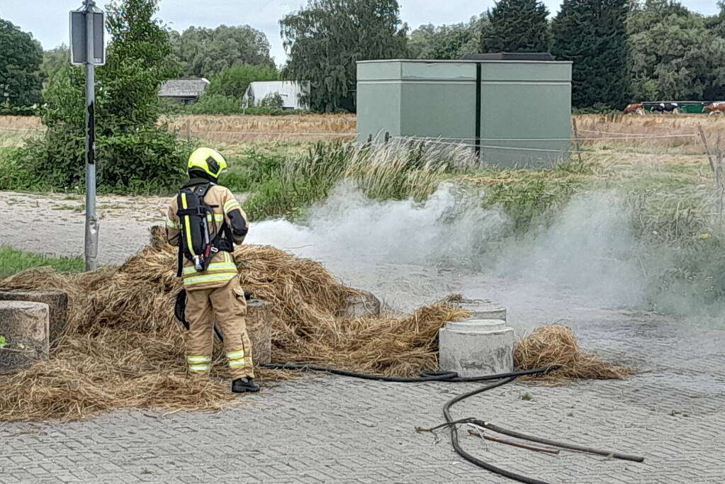 Brandweer blust brandende hooibaal