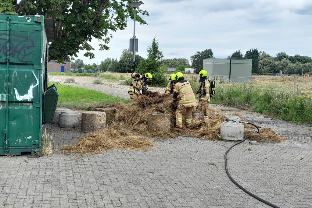 Brandweer blust brandende hooibaal
