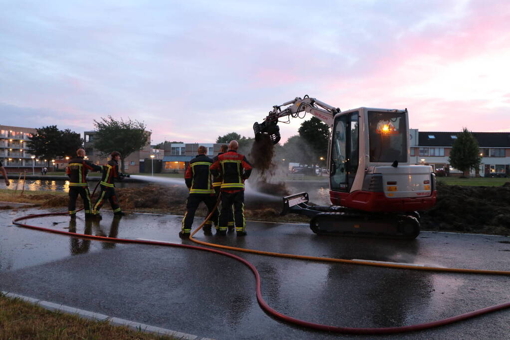 Stapel hooi langs de weg in brand gestoken