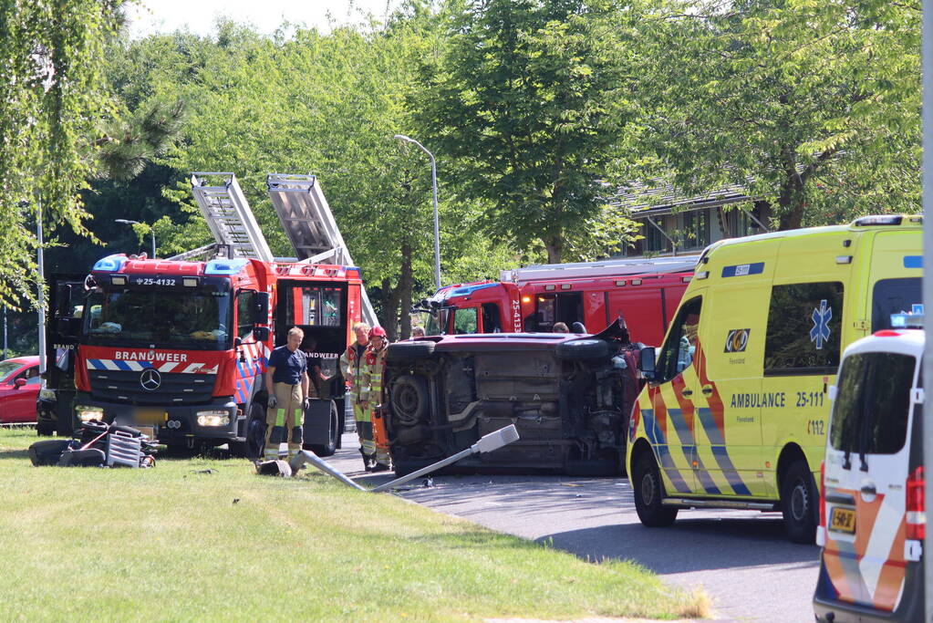 Auto op de kant na botsing met lantaarnpaal