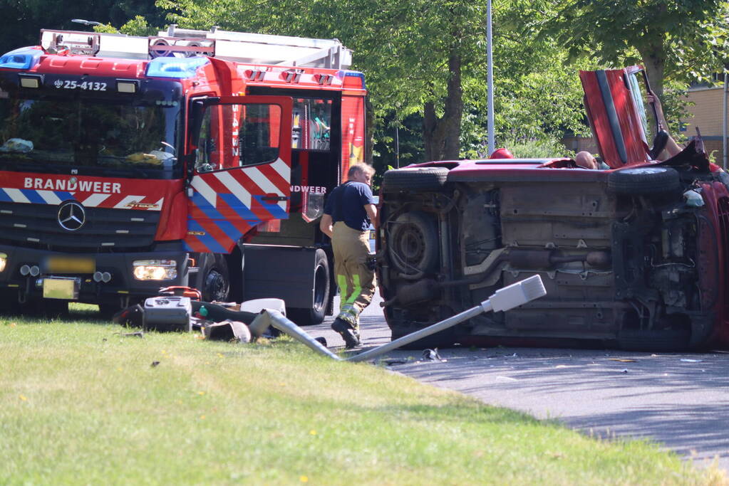 Auto op de kant na botsing met lantaarnpaal