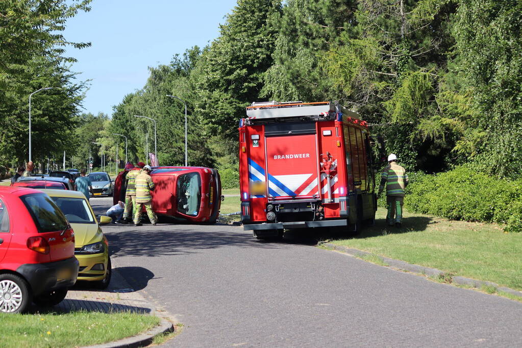 Auto op de kant na botsing met lantaarnpaal