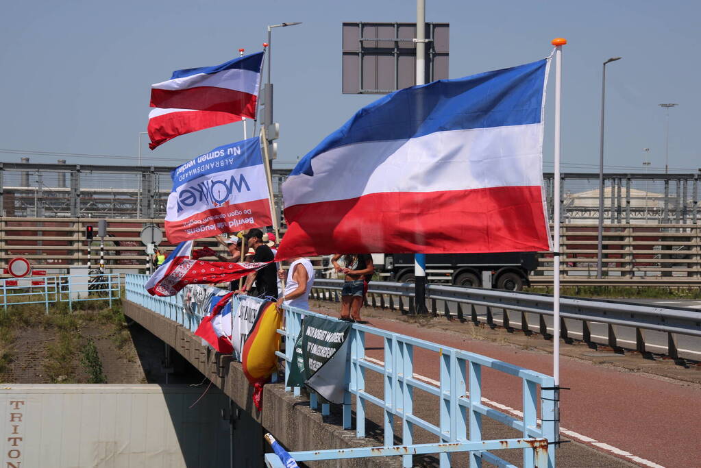 Actievoerders zwaaien met omgekeerde vlaggen naar verkeer op A15
