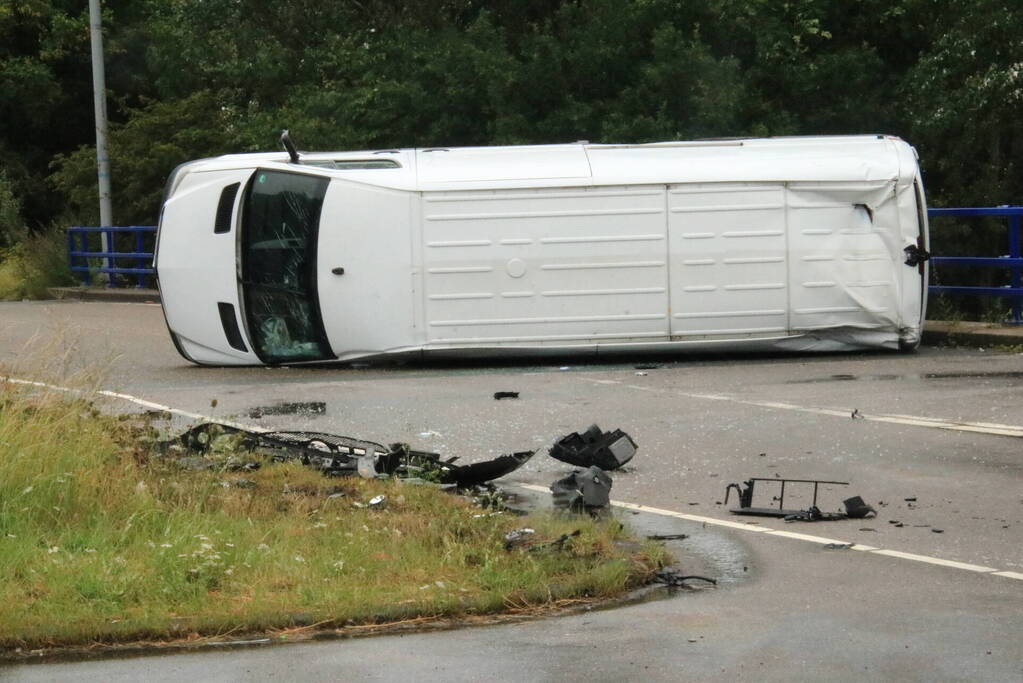 Bestelbus slaat om na botsing