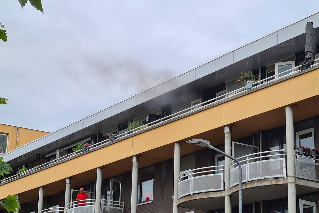 Zwarte rook uit appartement vanwege brand