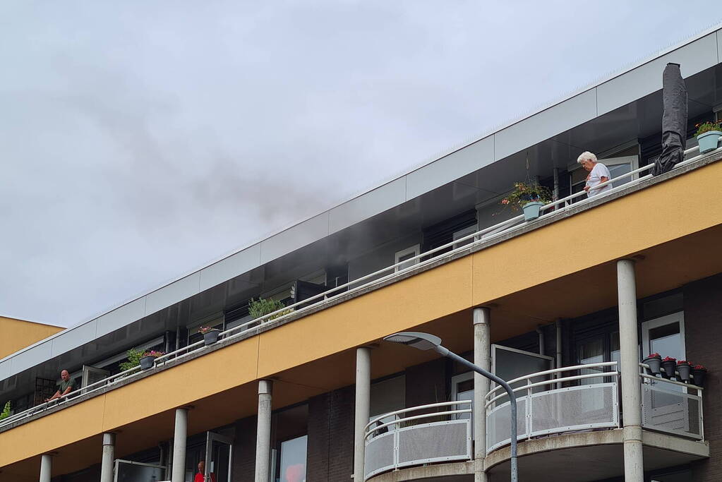 Zwarte rook uit appartement vanwege brand