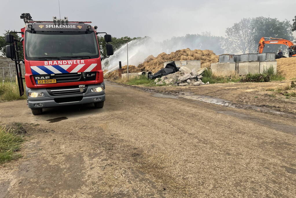 Grote berg met hooibalen in brand