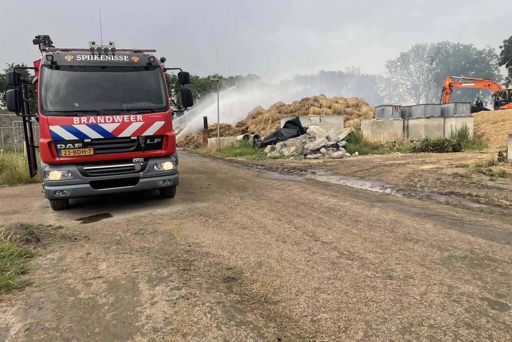 Grote berg met hooibalen in brand