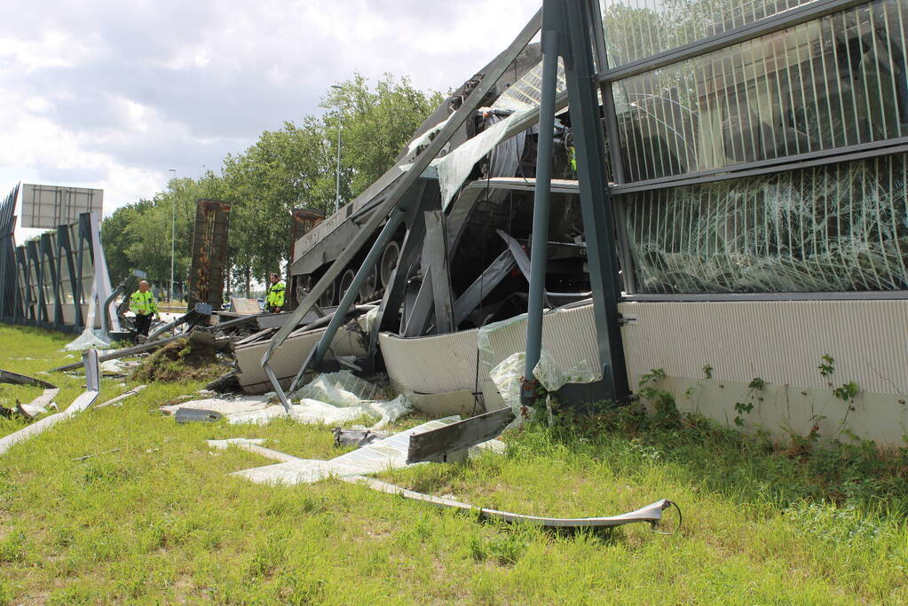 Vrachtwagen met gevechtstank boort zich in geluidswal
