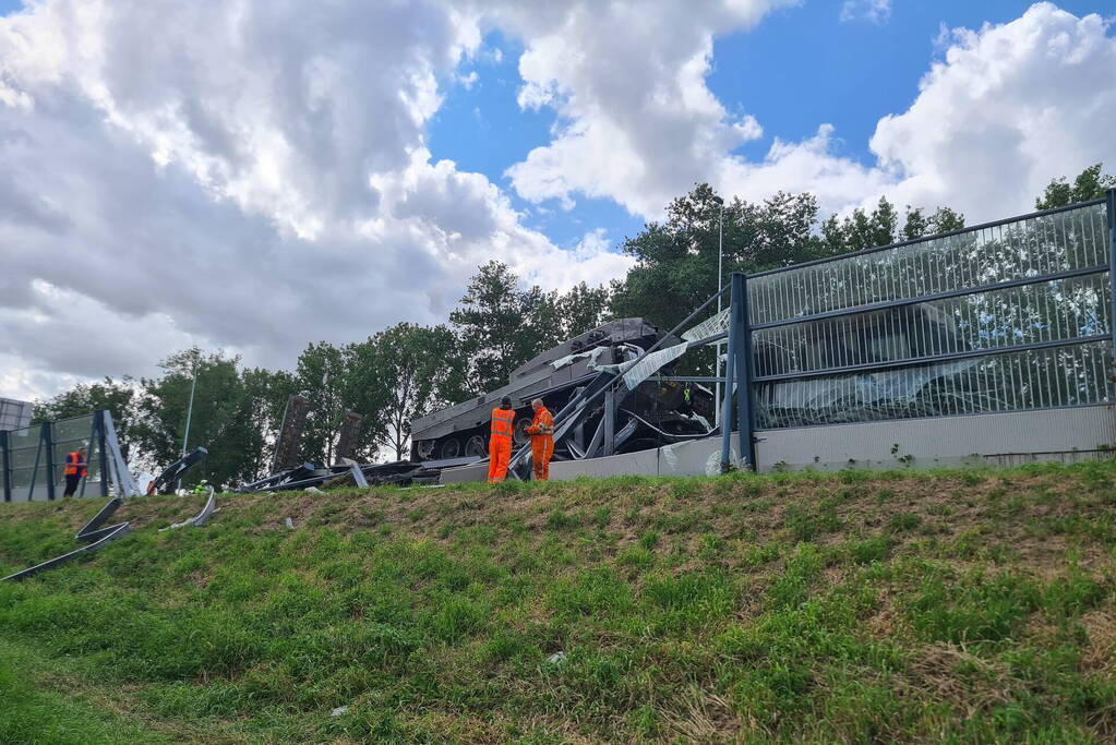 Vrachtwagen met gevechtstank boort zich in geluidswal