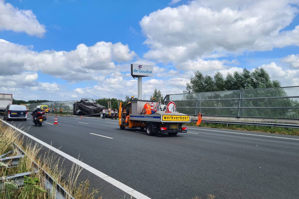 Vrachtwagen met gevechtstank boort zich in geluidswal
