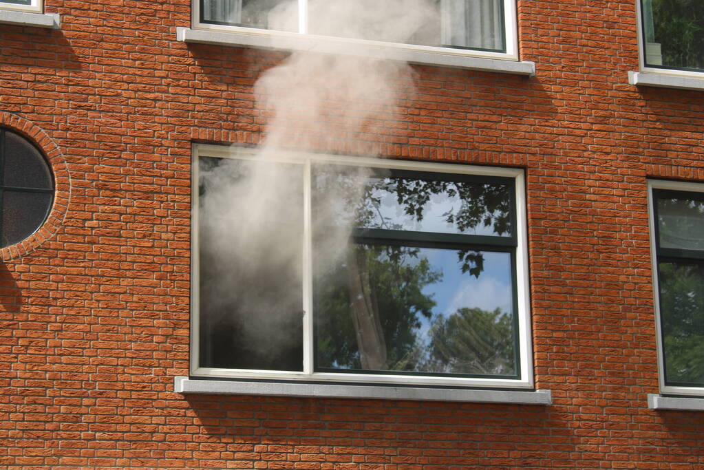 Veel rookontwikkeling vanwege brand in portiekwoning