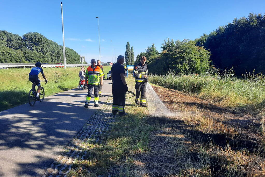 Omstanders doven bermbrand met kleed