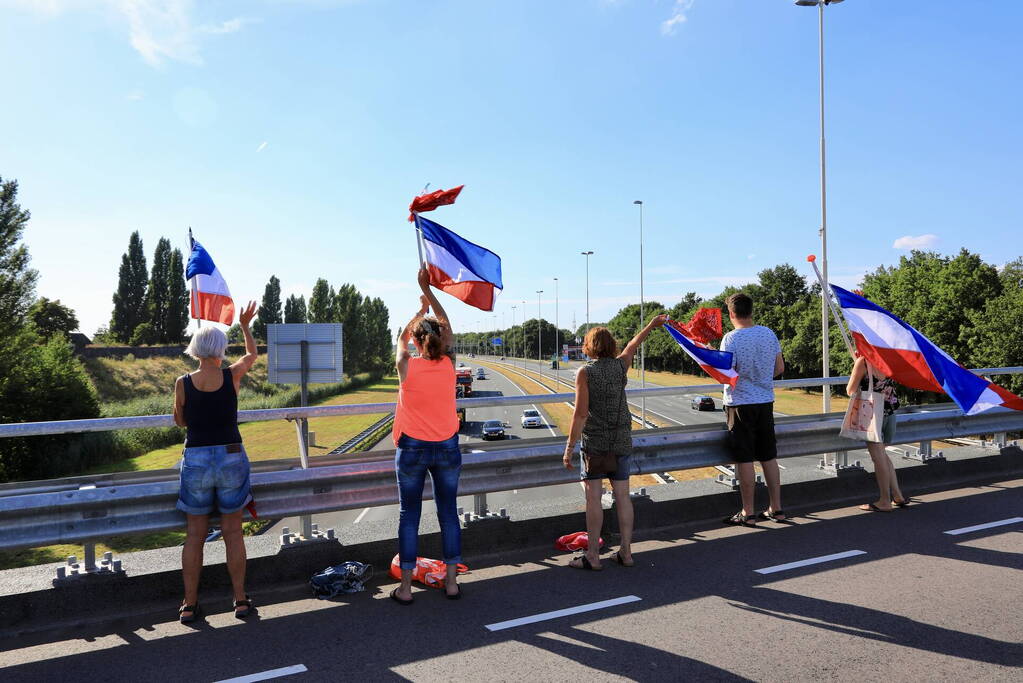 Verontrustende burgers staan met omgekeerde vlaggen zwaaien naar verkeer op A1