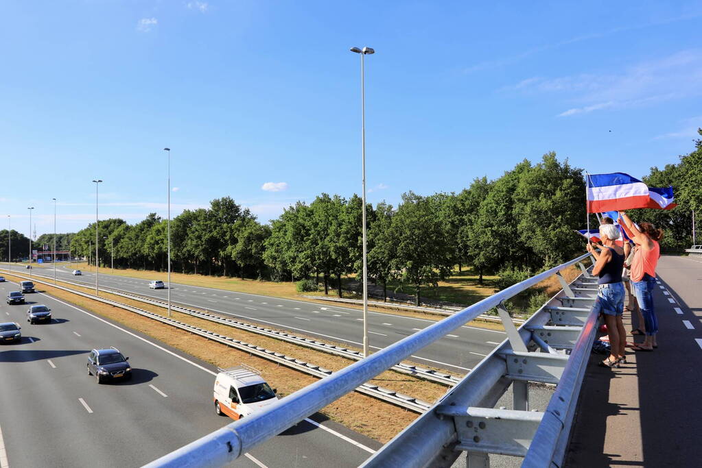 Verontrustende burgers staan met omgekeerde vlaggen zwaaien naar verkeer op A1