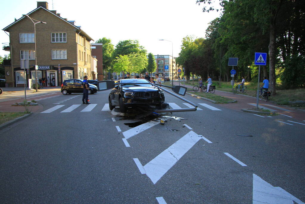 Personenauto uit de bocht, lantaarnpaal geraakt