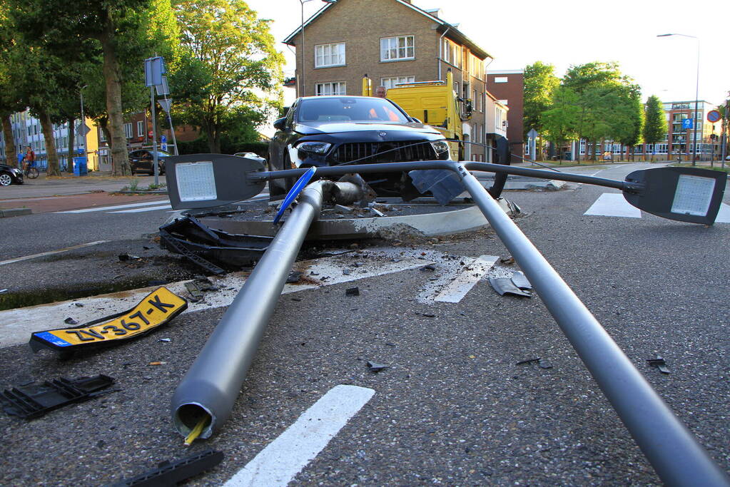 Personenauto uit de bocht, lantaarnpaal geraakt