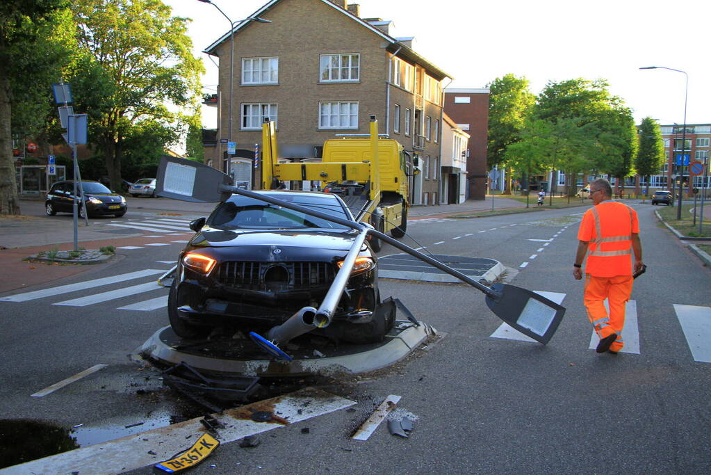 Personenauto uit de bocht, lantaarnpaal geraakt
