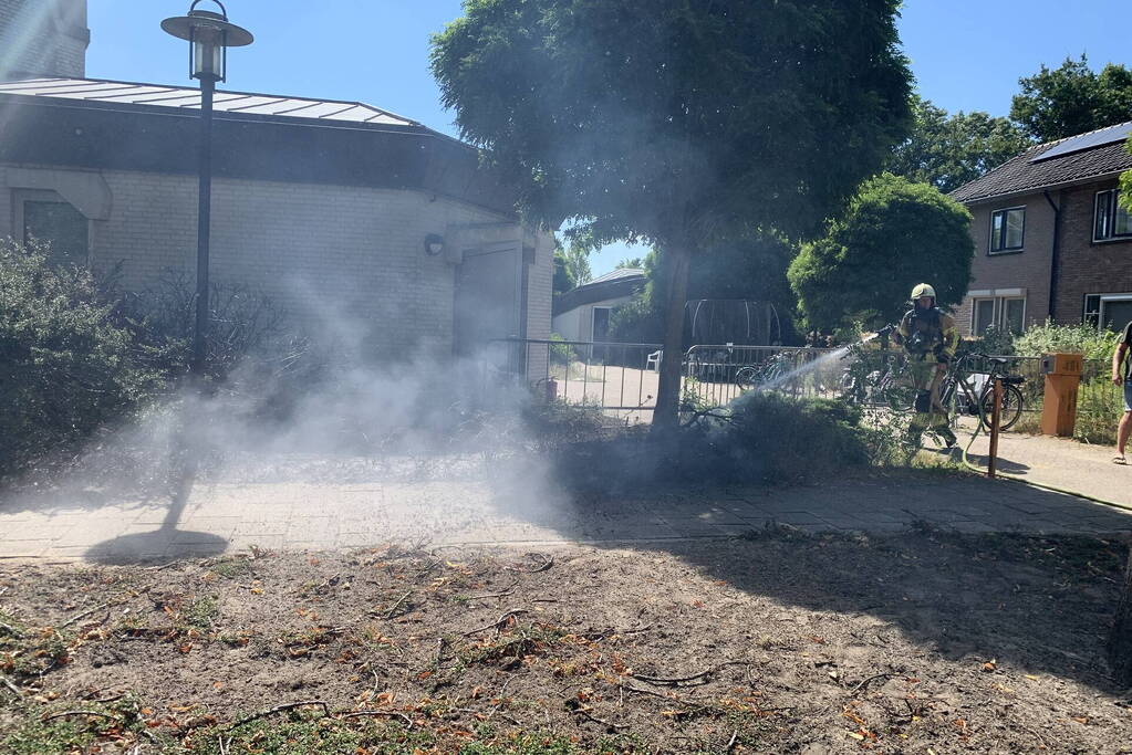 Brandende struiken naast gebouw snel geblust