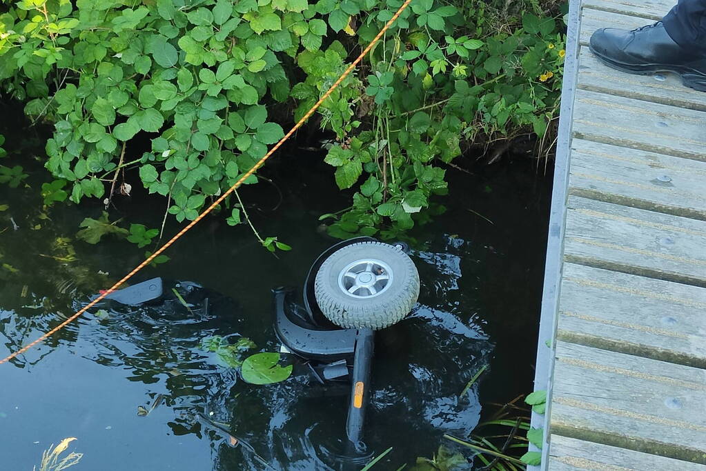 Man op scootmobiel rijdt vanaf brug het water in
