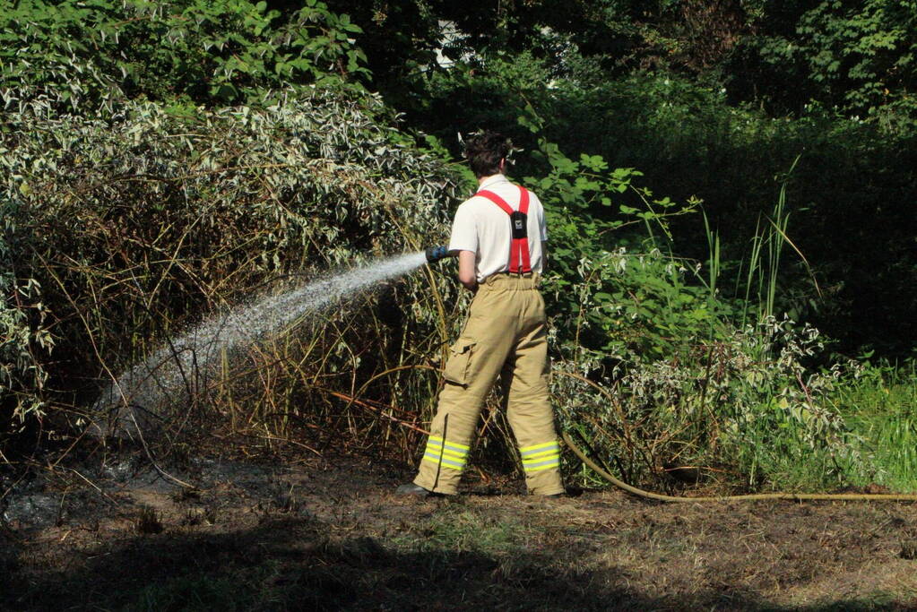 Brandweer blust brandende struiken
