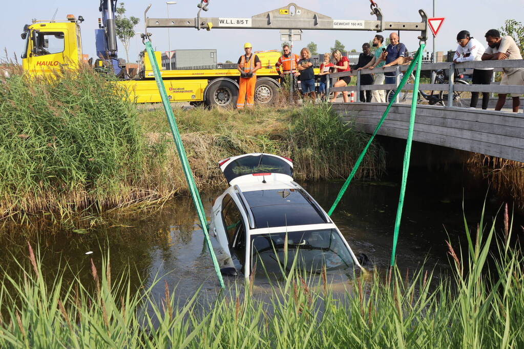 Auto raakt te water naast brug